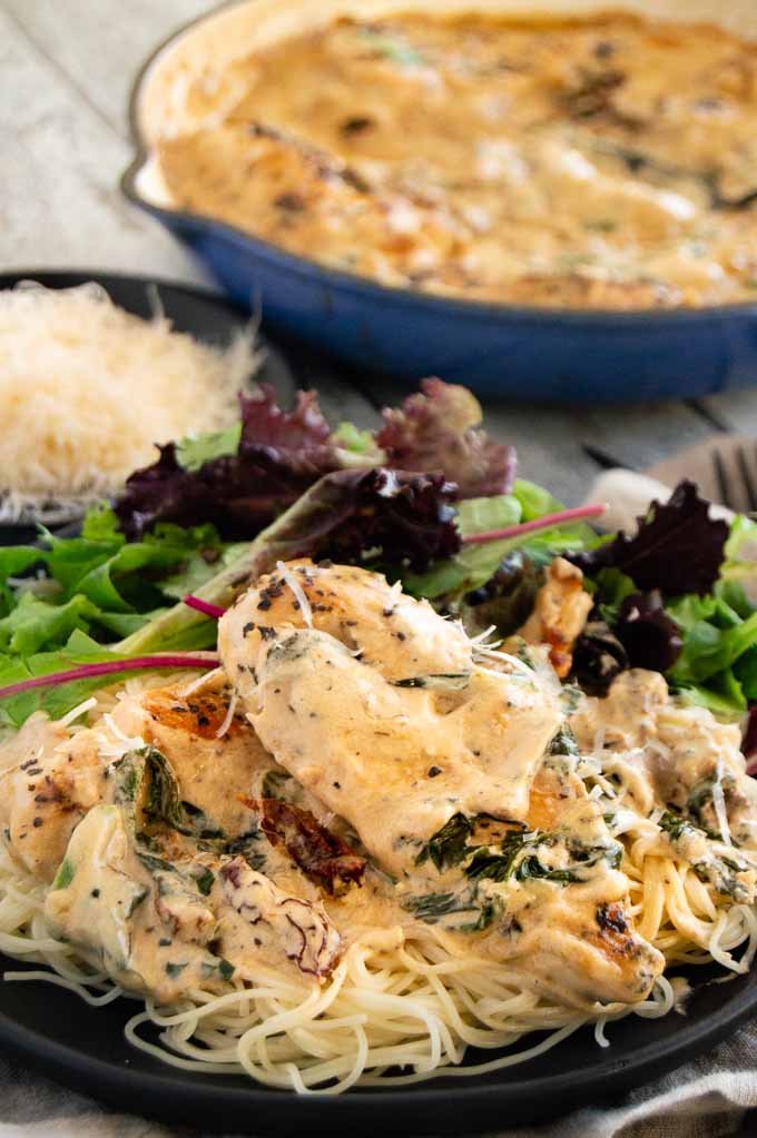Creamy Tuscan Garlic Chicken is the easiest gourmet meal to make ever!  One-pan stove top chicken that is tender and juicy in a creamy tangy garlic parmesan sauce with sun-dried tomatoes and spinach.